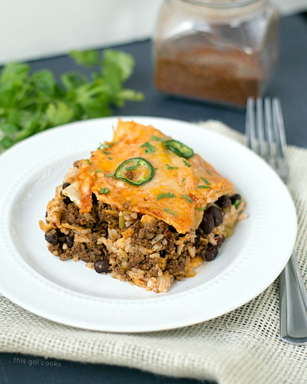 My favorite Taco Lasagna is an easy dinner recipe that combines my favorite tex mex flavors into one beefy, cheesy casserole dish! | This Gal Cooks