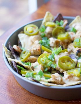 Cilantro Lime Chicken Nachos: lime and blue tortilla chips are topped with cilantro lime grilled chicken, homemade cheese sauce, jalapeños and green onions. Simple but crazy good.