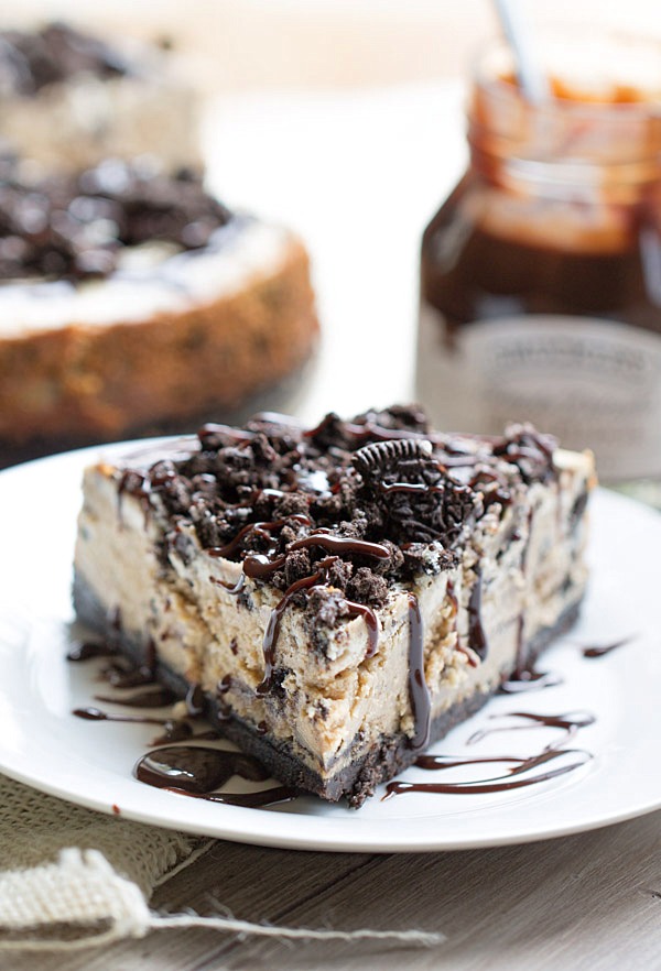 The BEST Peanut Butter Oreo Cheesecake. This creamy peanut butter cheesecake is filled and topped with Oreo cookies and drizzled with hot fudge! | This Gal Cooks