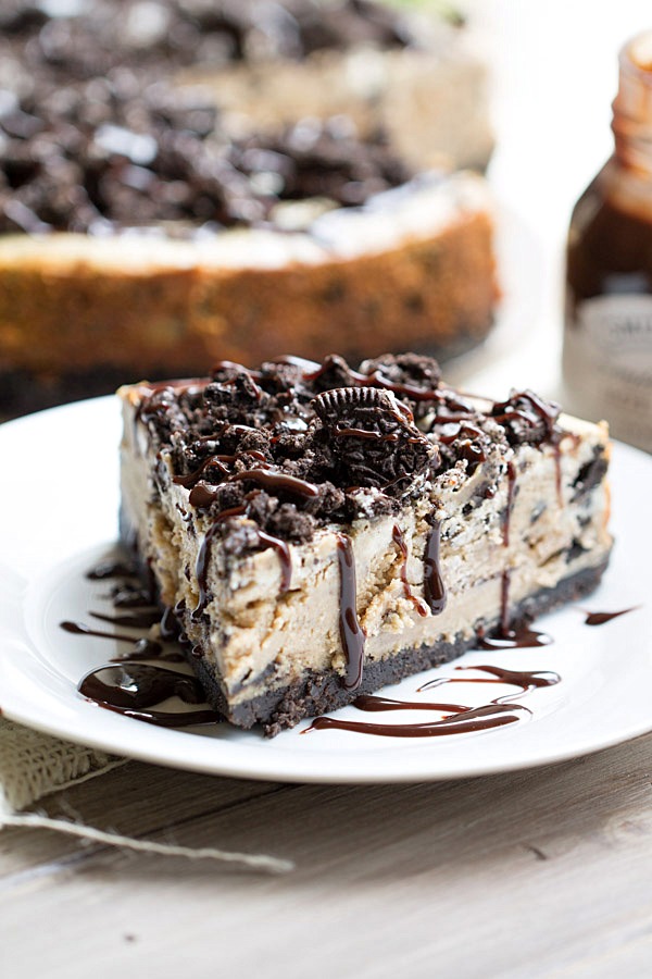 The BEST Peanut Butter Oreo Cheesecake. This creamy peanut butter cheesecake is filled and topped with Oreo cookies and drizzled with hot fudge! | This Gal Cooks