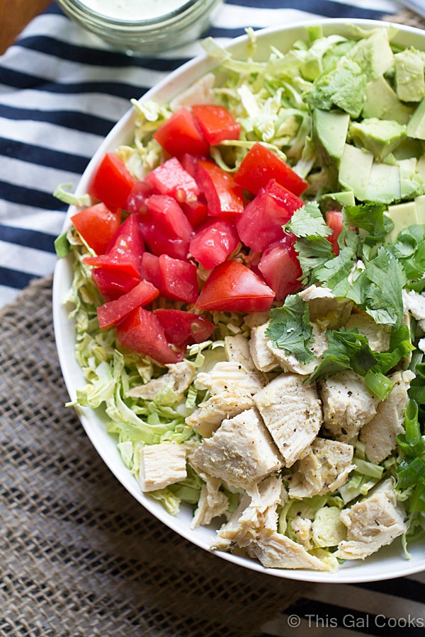 Shaved Brussels Sprout Salad with Creamy Cilantro Dressing is a simple and flavorful salad that's perfect for lunch or a light dinner. This salad is packed with chicken, avocado, tomatoes and queso fresco!