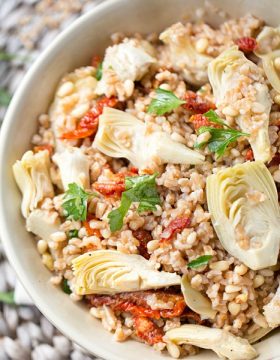 Farro Salad is packed full of tender sun dried tomatoes, artichokes and crunchy pine nuts. Tossed with an olive oil, red wine and Greek seasoning dressing for an outstanding pop of flavor!