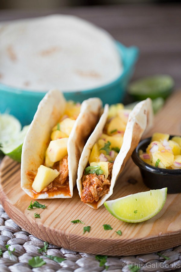 Shredded Chicken Tacos are a simple and delicious dinner recipe that's made in your slow cooker. The tacos are topped with an out of this world fresh homemade pineapple salsa! 