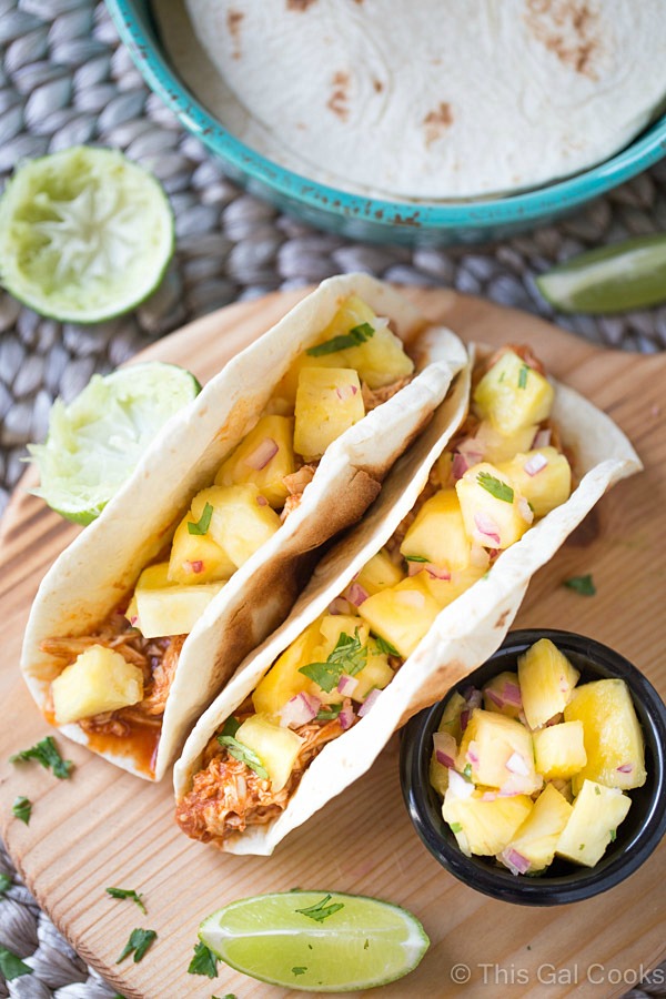 Shredded Chicken Tacos are a simple and delicious dinner recipe that's made in your slow cooker. The tacos are topped with an out of this world fresh homemade pineapple salsa! 