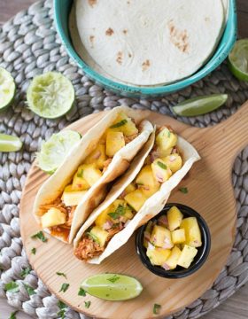 Shredded Chicken Tacos are a simple and delicious dinner recipe that's made in your slow cooker. The tacos are topped with an out of this world fresh homemade pineapple salsa!