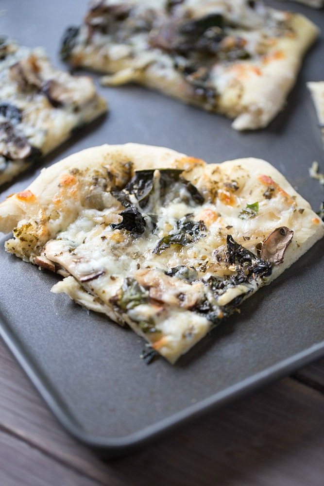 Save money by making your own homemade veggie pizza. Loaded with kale, mushrooms and basil pesto!