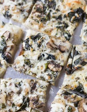 Save money by making your own homemade veggie pizza. Loaded with kale, mushrooms and basil pesto!