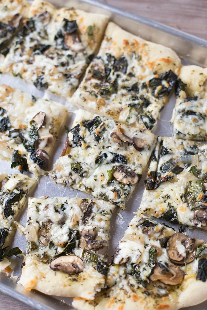 Save money by making your own homemade veggie pizza. Loaded with kale, mushrooms and basil pesto!
