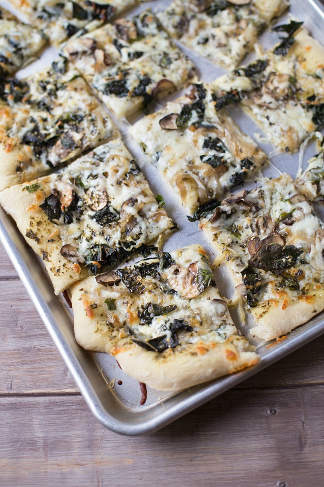 Save money by making your own homemade veggie pizza. Loaded with kale, mushrooms and basil pesto!