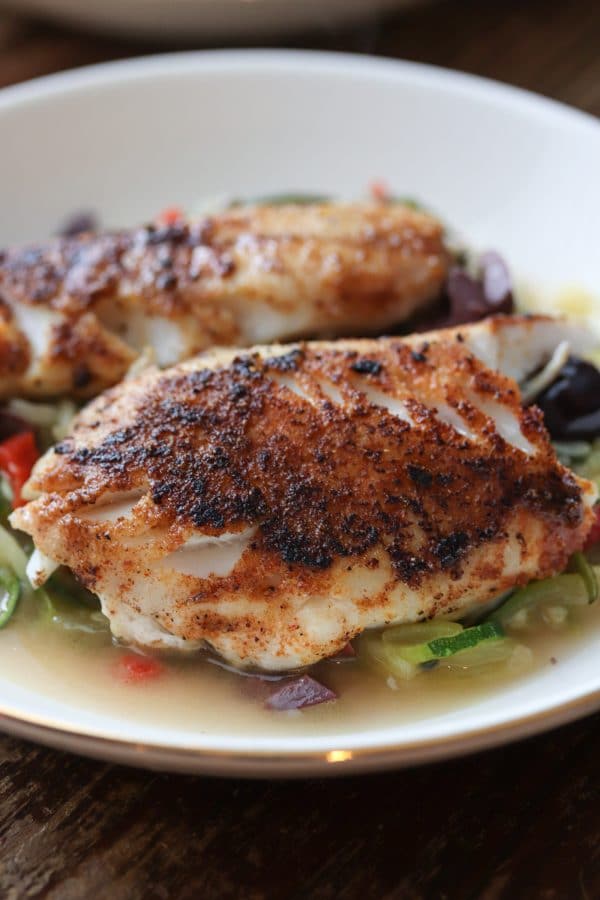 Delicious and healthy mediterranean seasoned Black Sea Bass served with grain free and low carb zucchini noodles. SO easy to make and ready to serve in under 30! #seafood #seabass #lowcarb #glutenfree #dinner #keto